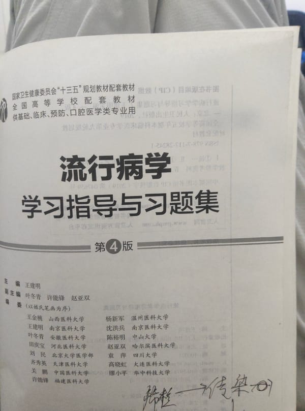 Student studies epidemiology textbooks in Chongqing dorm room