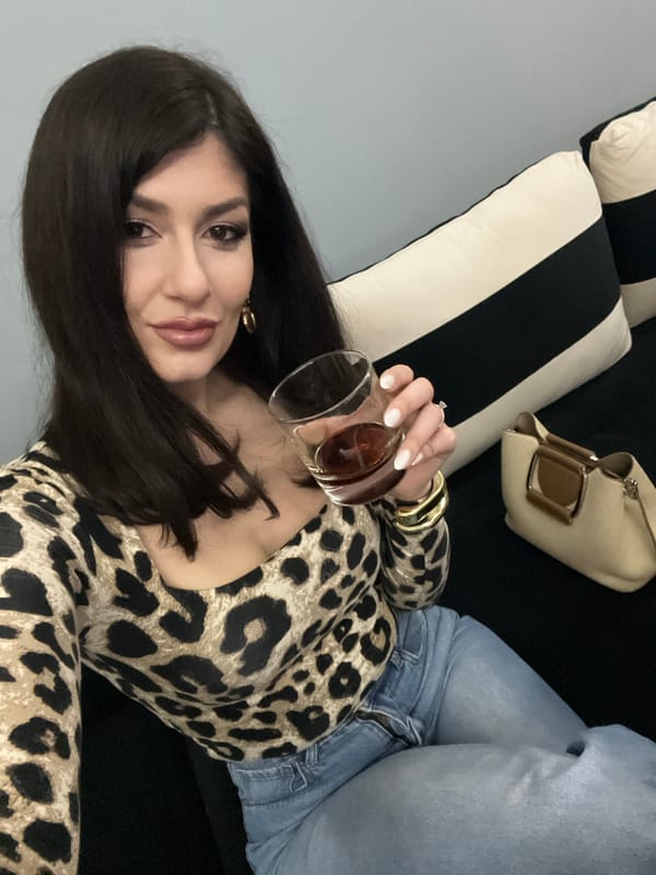 Woman with drink relaxes on sofa in Yambol