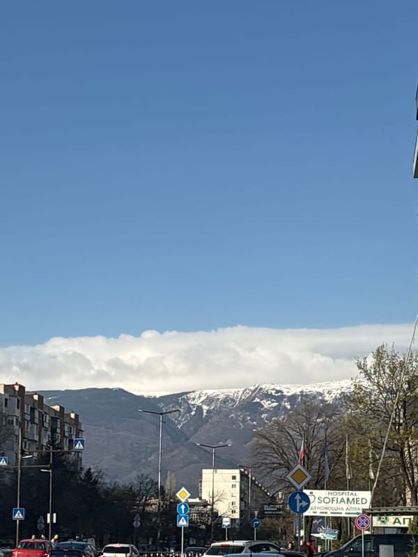 Mountain clouds blanket Sofia street scene with signage