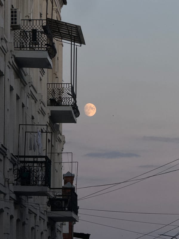 Full moon rises over Vinnytsia balconies at dusk