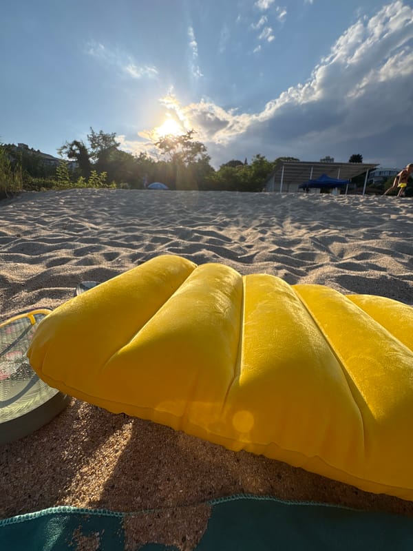 Yellow inflatable mat on a sandy beach at golden hour