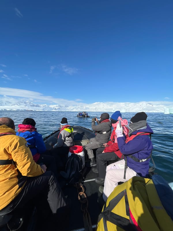 Tourist expedition boat navigates Antarctic waters near icebergs