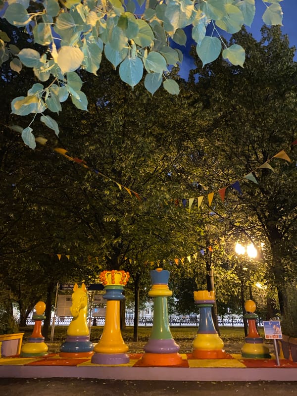 Live performances and giant chess pieces at a nighttime outdoor event