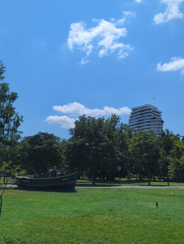Fishing boat display and parked cars in an urban park setting