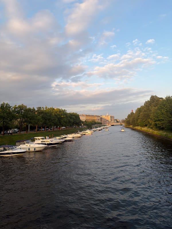 Golden hour along a city waterfront with boats and river views