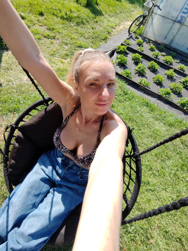 Woman enjoys outdoor swing session with cooking setup nearby