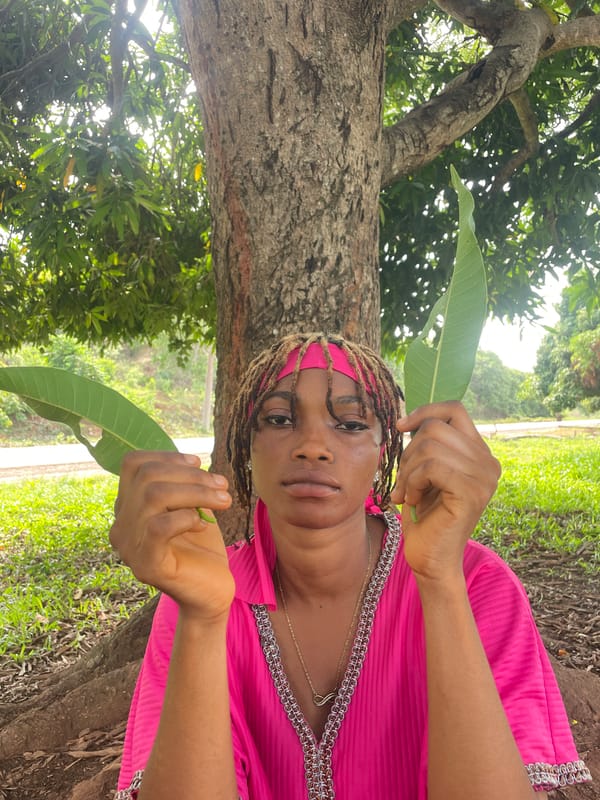 Woman poses with mango leaves in outdoor Nigeria portrait