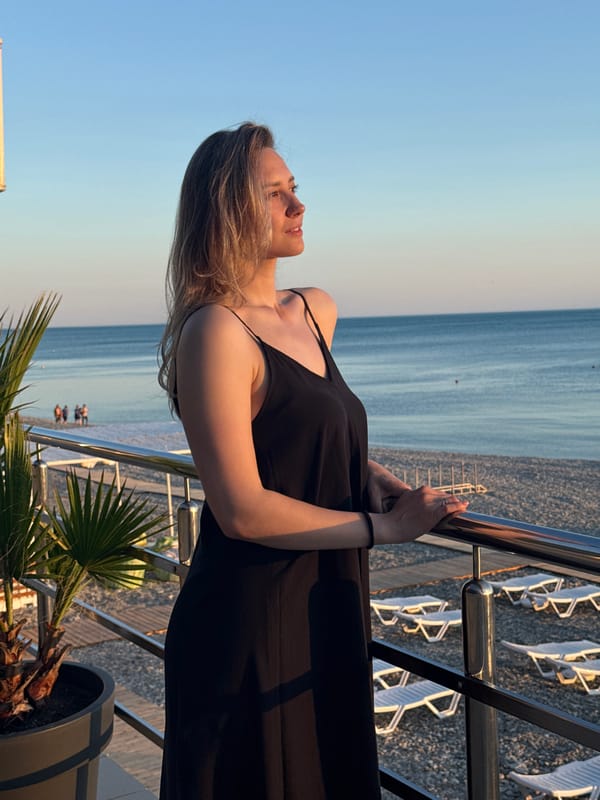 Woman enjoys golden hour moment on Nebug beach balcony