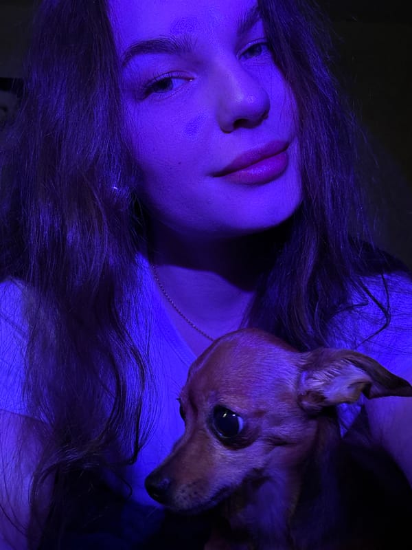 Woman and small dog share quiet moment indoors in Chaikovsky