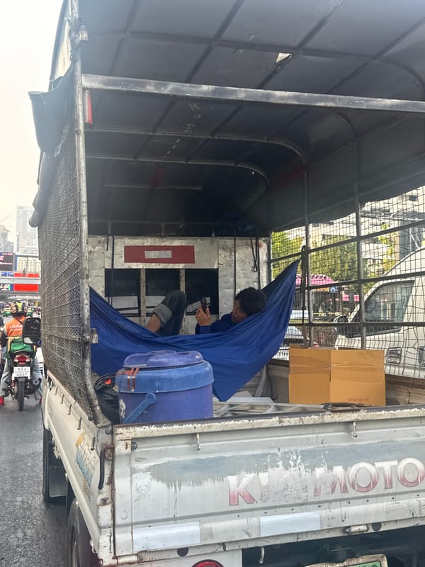 Man rests in utility truck on Bangkok street