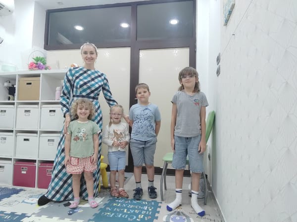 Woman poses with four children in Podgorica play area
