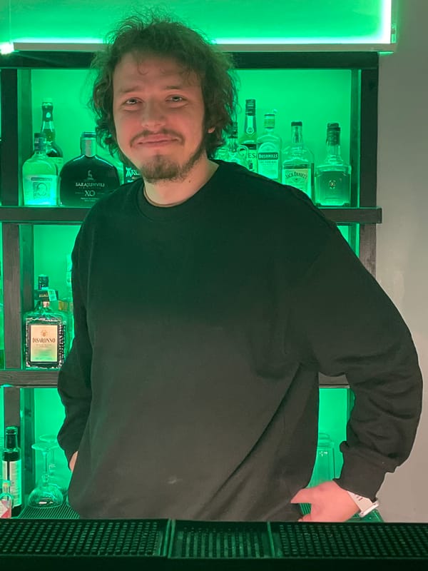 Man stands at illuminated bar in Belgrade