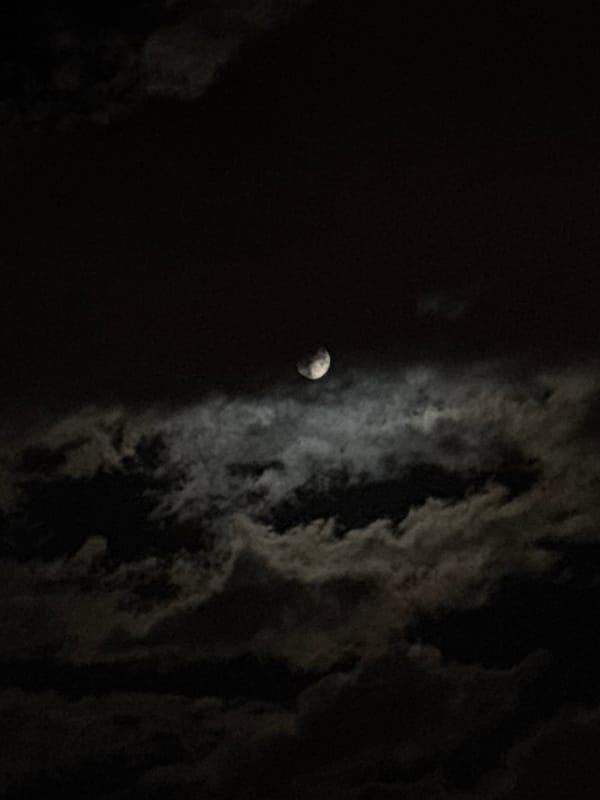 Cloudy moon photographed over Minsk evening sky