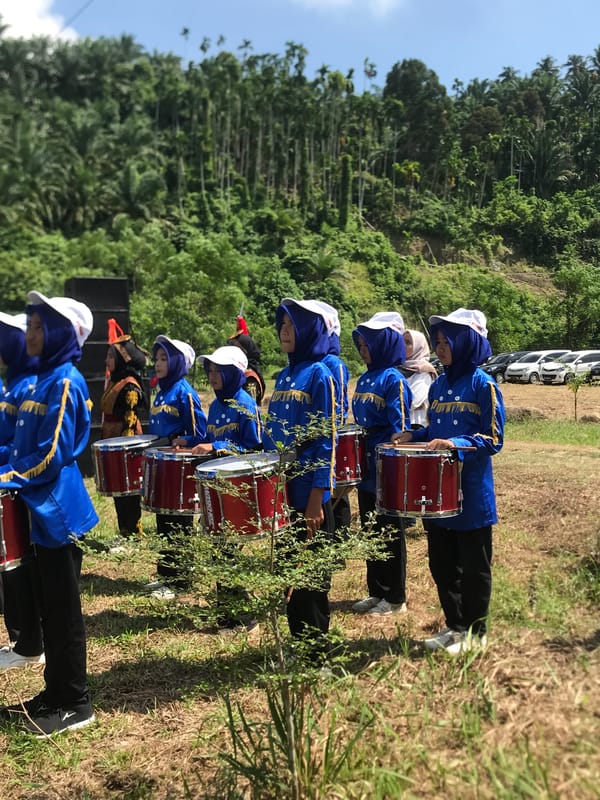 Marching band performs drumline routine at outdoor event in Langkuta