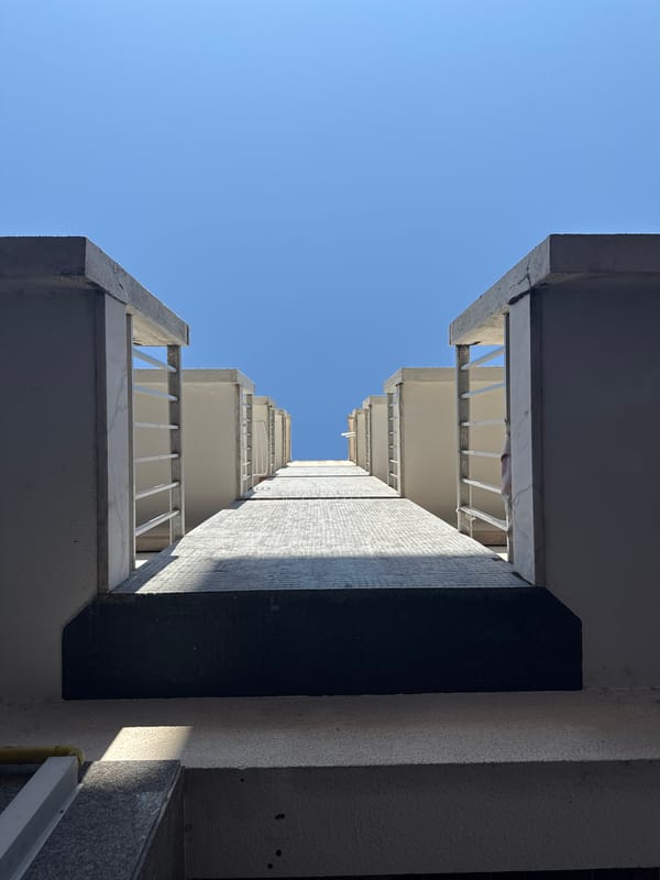 Looking up between two beige apartment blocks in Oeiras