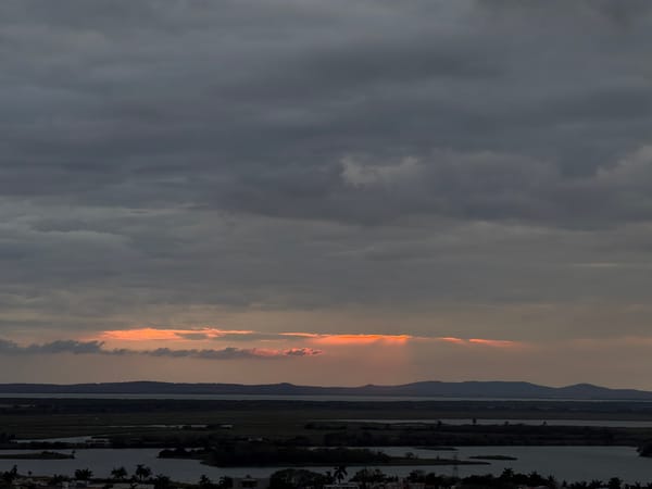 City observed under dramatic cloudy skies at dawn