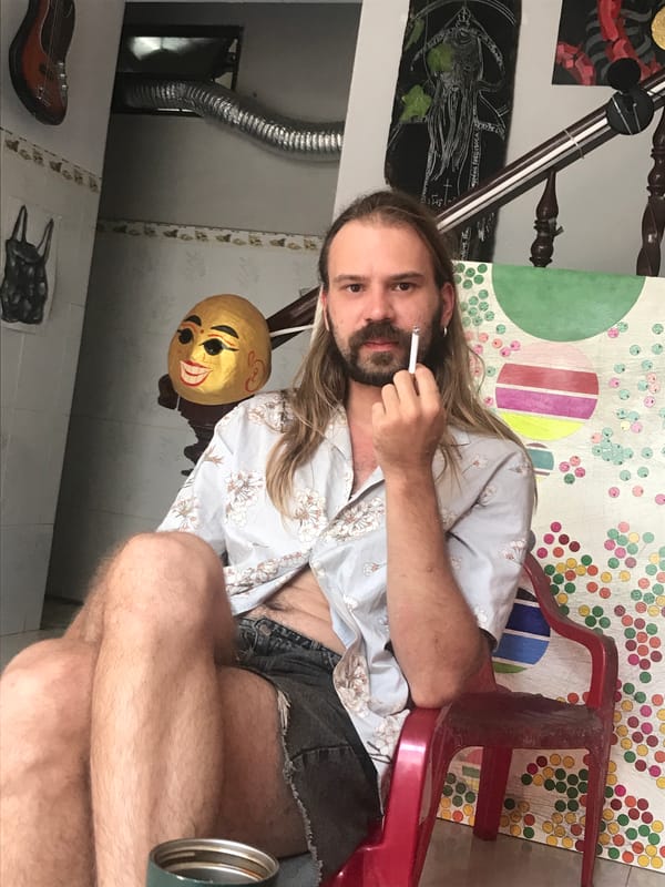 Person smoking cigarette on red chair in Nha Trang