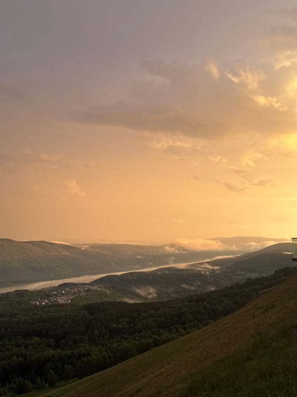 Rainbow over Krasnoyarsk at golden hour, Yenisei River below