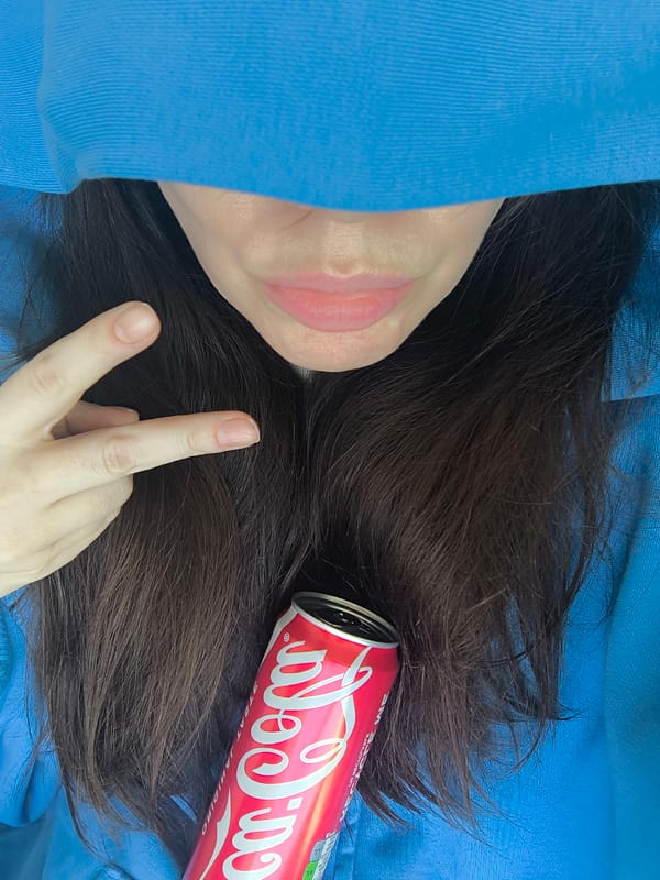 Person drinks Coke, accesses alcohol-free wine from fridge