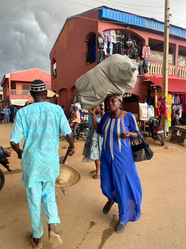 Woman carries sack under stormy skies in Kafanchan