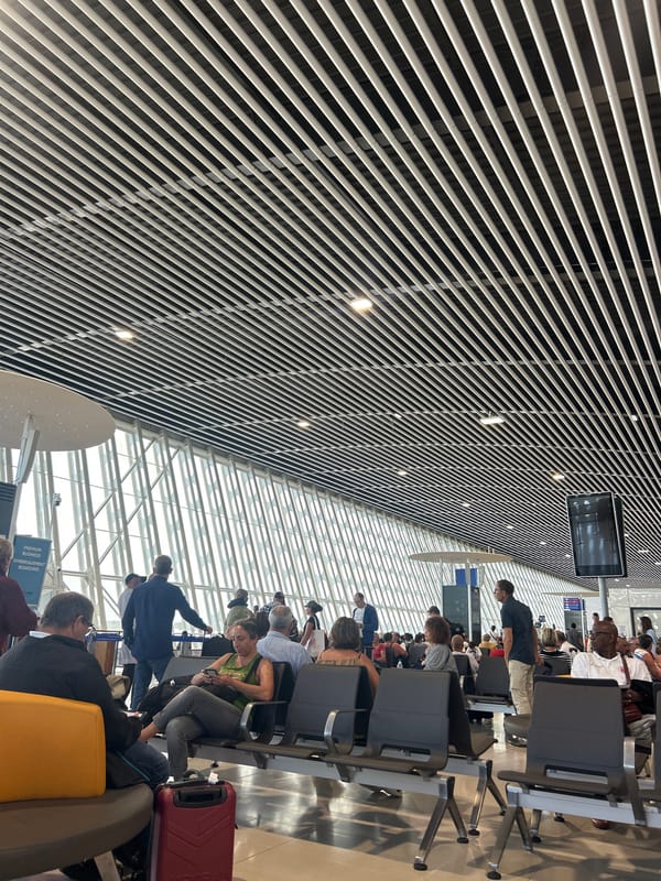 Travelers wait at Guadeloupe airport departure hall