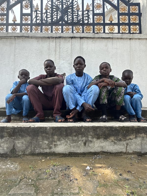 Young males gather on concrete steps in Ado, Nigeria