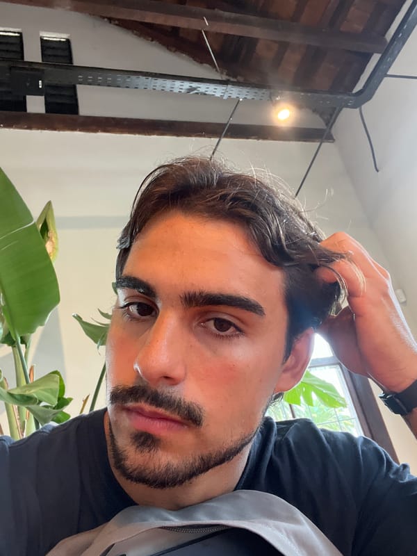 Man takes close-up selfie while holding hair strand