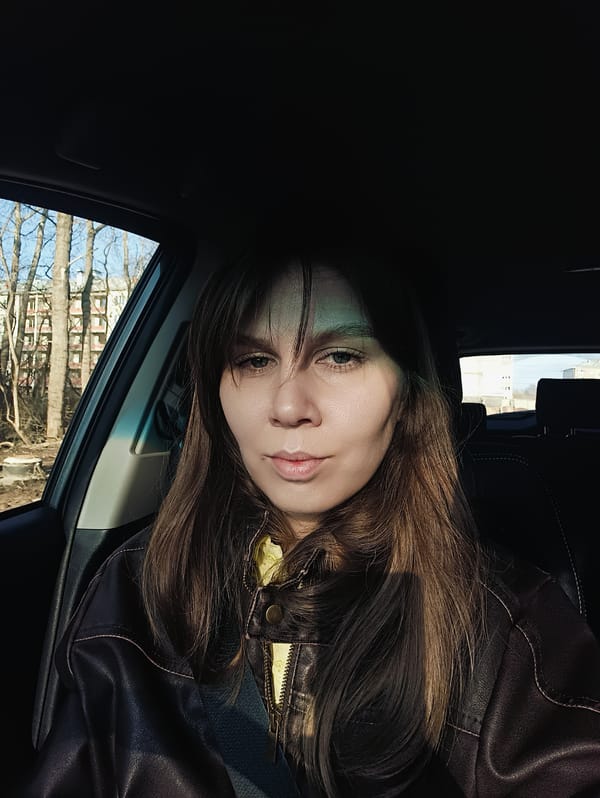 Woman drives dirt road, takes selfie during morning hours