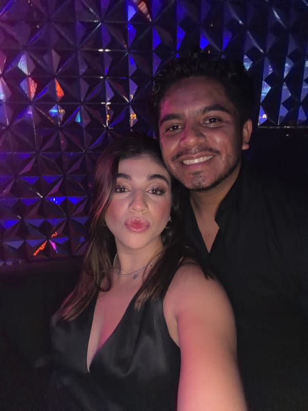 Couple takes selfies in blue-lit indoor space in Mexico