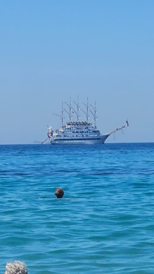 Pirate tour boats and swimmers on Alanya's Mediterranean coast