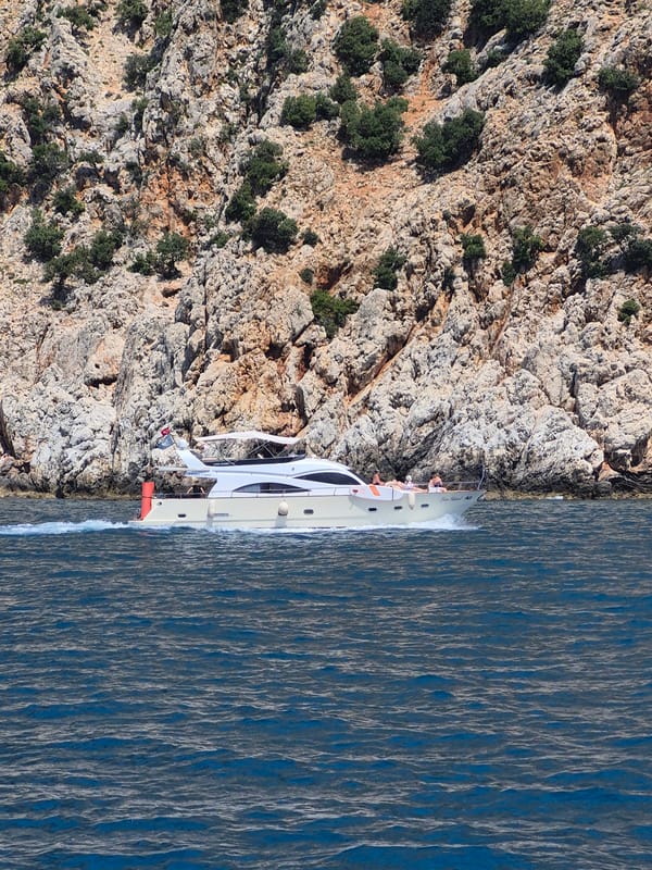 Tourist boat cruises near Alanya Castle cliffs, Turkey