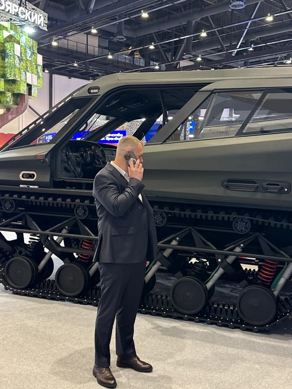 Man takes phone call beside tracked vehicle in Pushkin