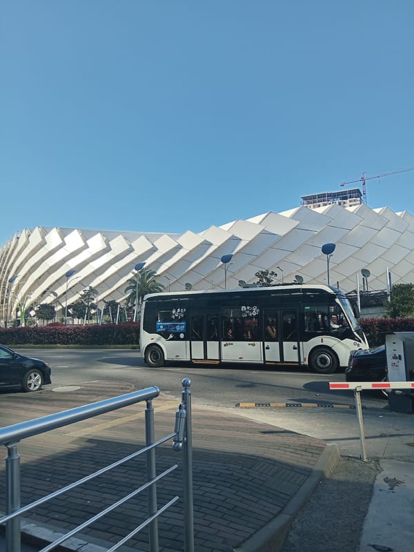 City bus stops near modern triangular building in Batumi