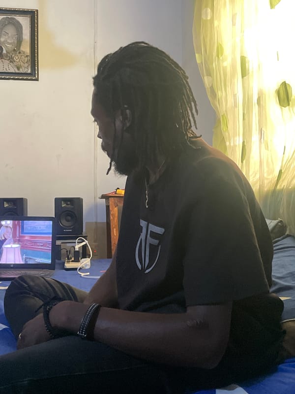 Chilling indoors in Jos, Nigeria — laptop, phones, and downtime