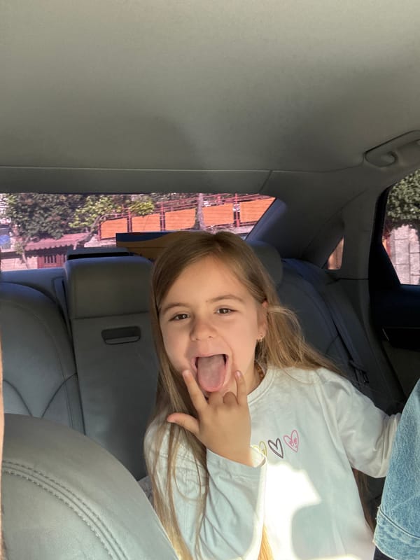 Girl makes playful gestures in car in Rila, Bulgaria