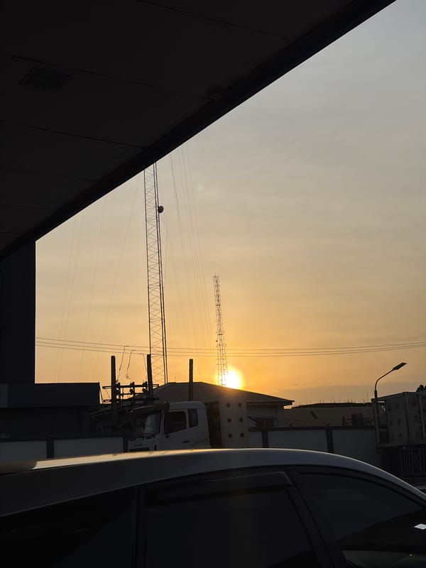 Construction cranes silhouetted against golden sunset in Lekki, Nigeria
