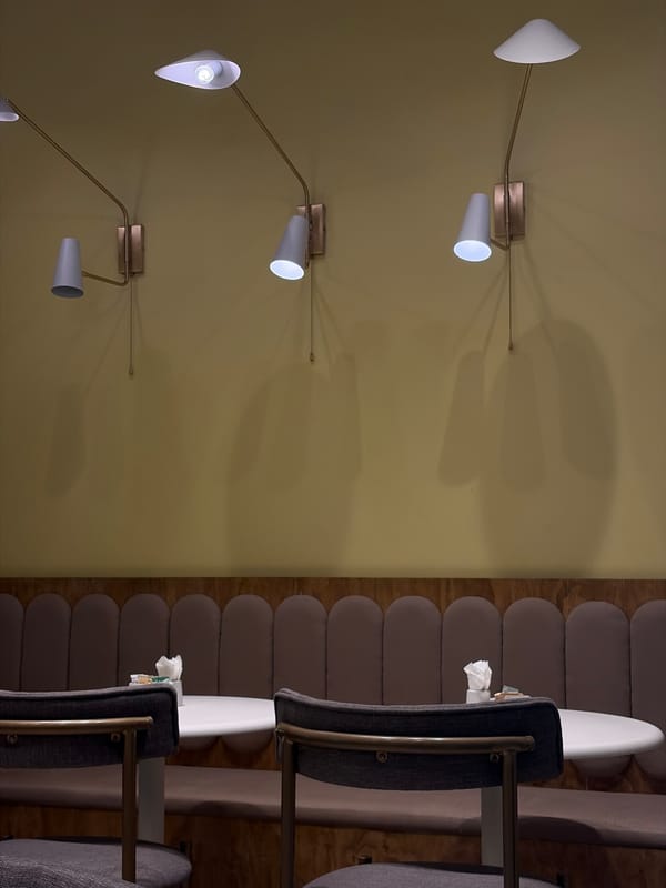 Indoor scene features wall lamps and red rose arrangements