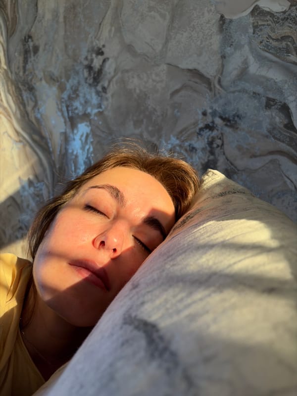 Woman rests in sunlit bedroom in Izhevsk