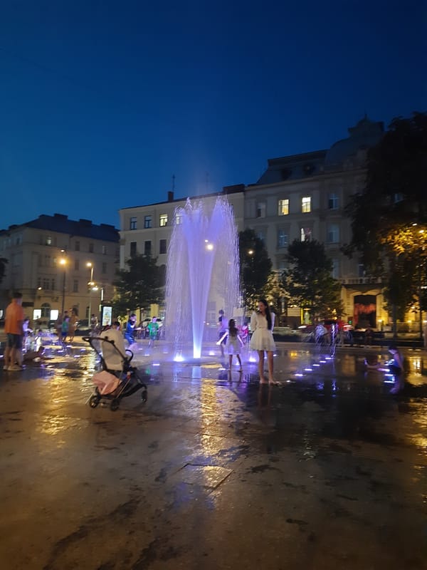 Lviv fountain glows purple and white at dusk