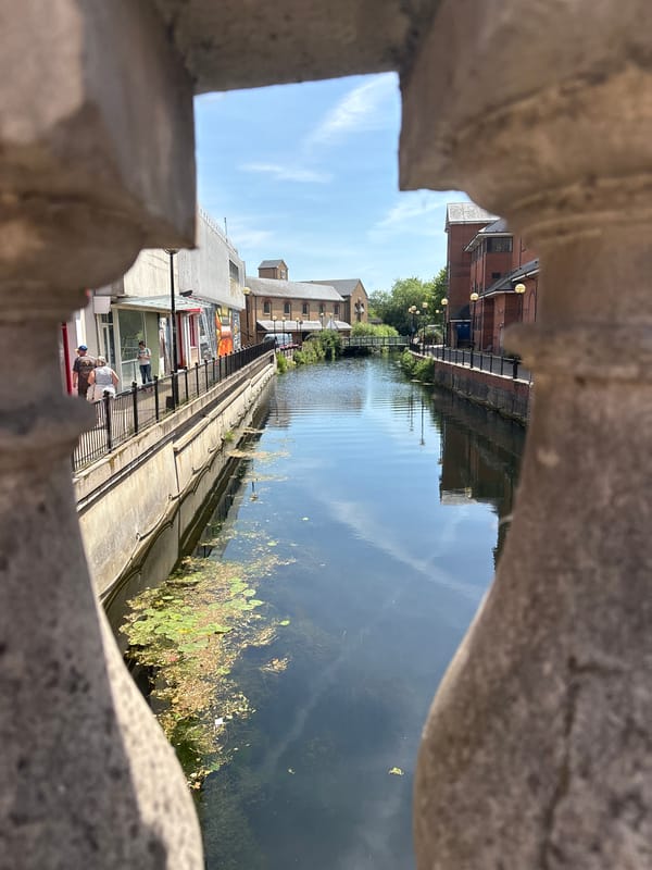 Sunny canal district: brick streets, murals, and midday foot traffic