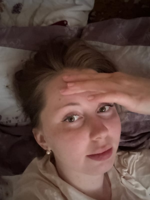 Young person photographed smiling at camera while lying down