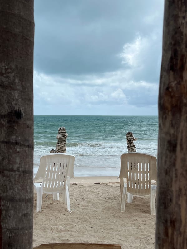 Beach morning setup captured with chairs and striped umbrella