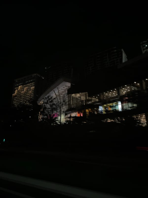 Illuminated shopping mall observed at night in Babakan Madang