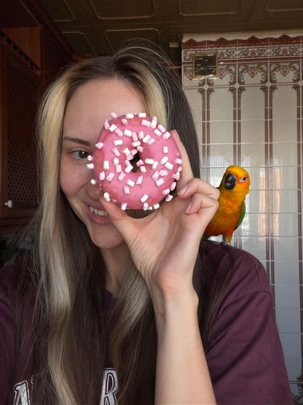 Woman poses with pet parrot and donut in Khimki