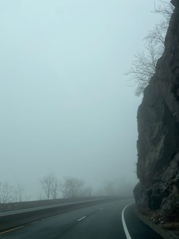 Dense fog blankets West Point road amid rocky cliffs