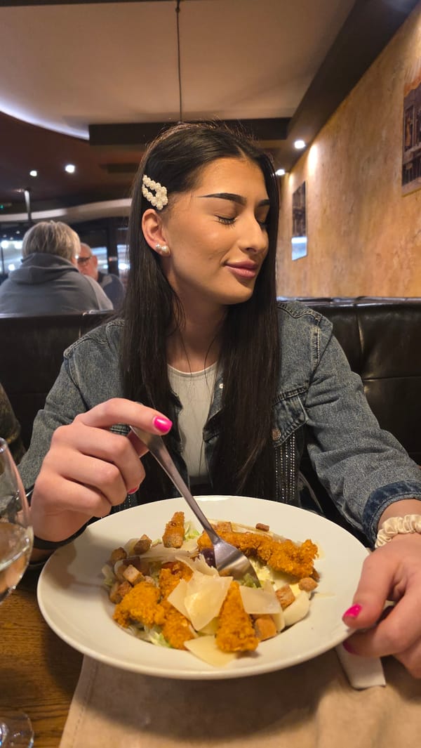 Woman dines alone at dimly lit restaurant wearing denim