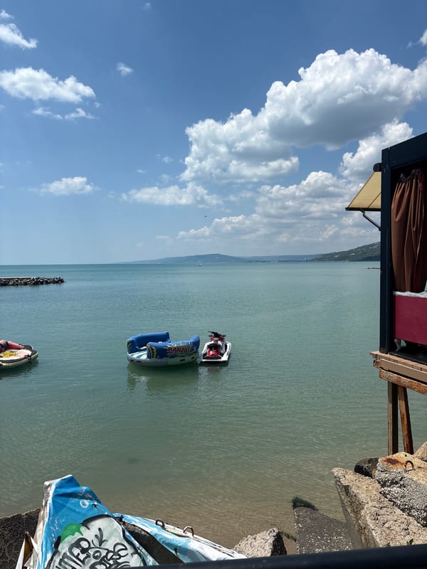 Sunny morning at a coastal resort with pools, boats, and waterfront views