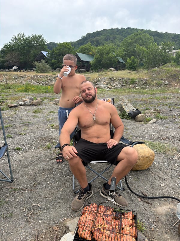 Family barbecue picnic by river in Plastunka, Russia