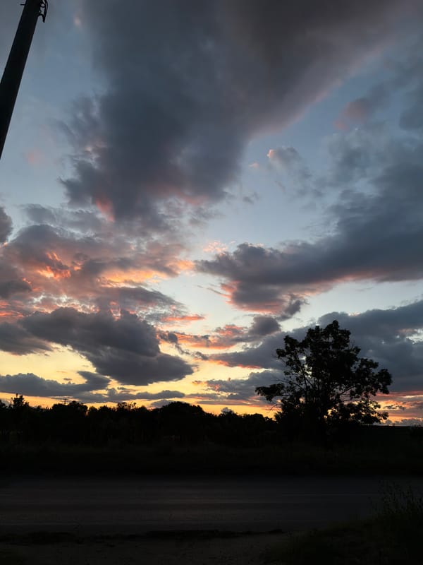 Storm clouds and sunset colors over a rural Sofia road at dusk