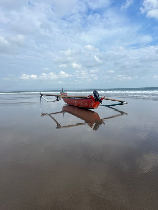 Red boat resting on the beach in North Kuta, Bali